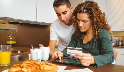 couple-online-shopping-together-while-having-breakfast-kitchen-home